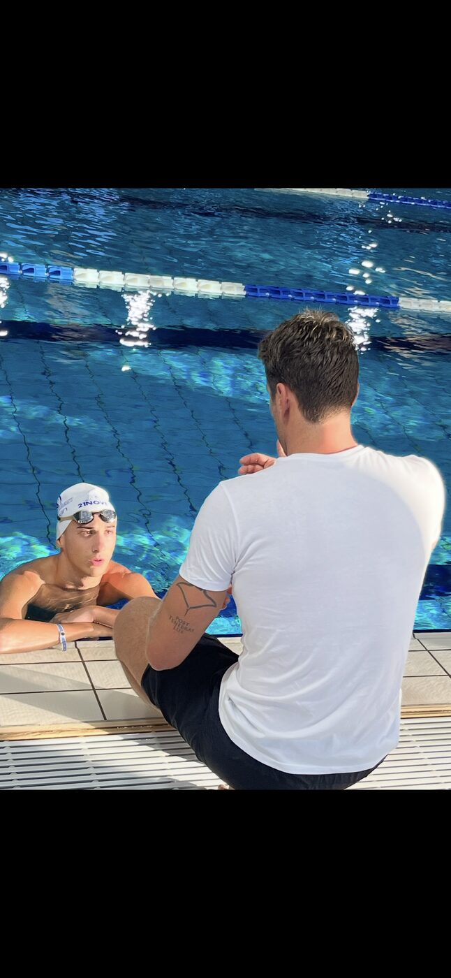 Coach 21Nove parla con una nuotatrice a bordo piscina